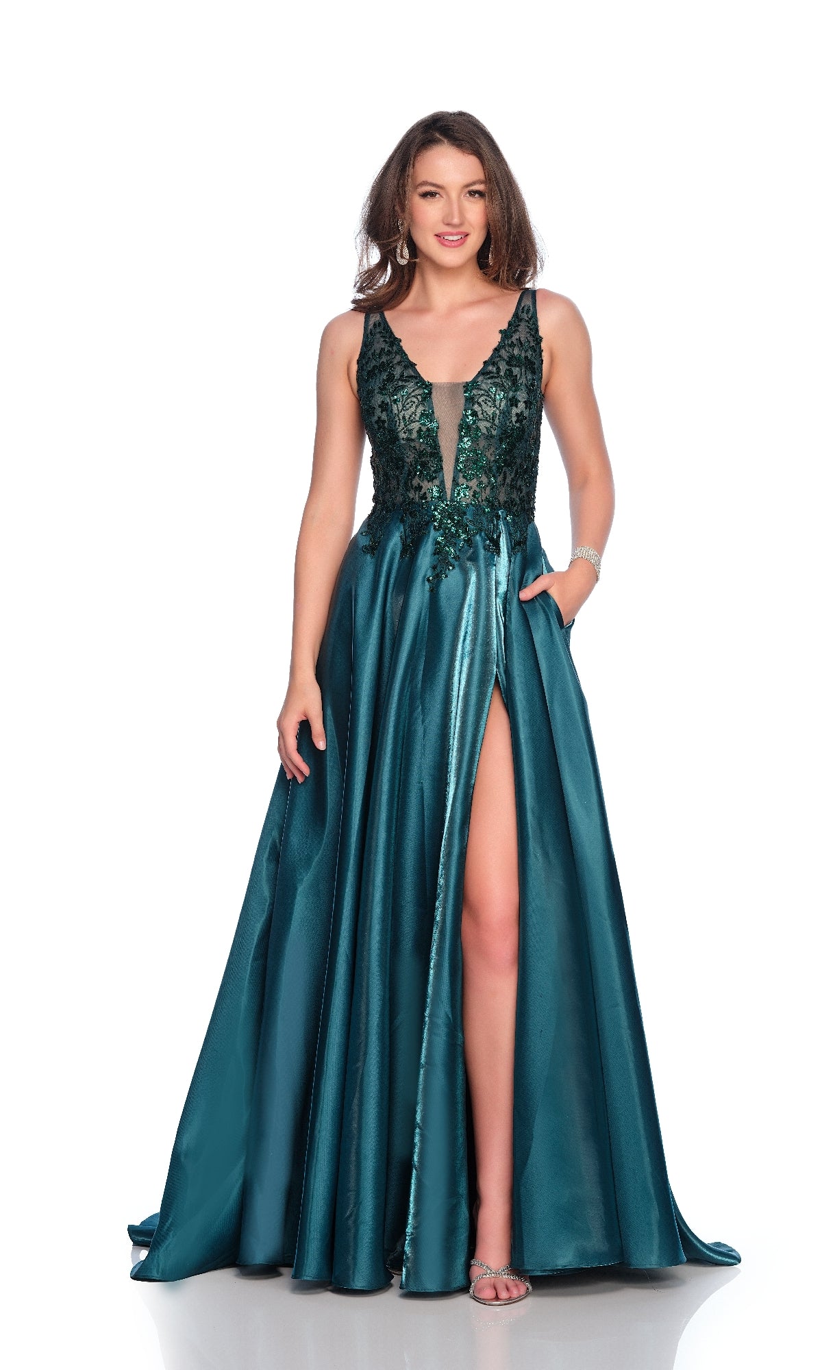 A woman models the Dave & Johnny 12104 emerald green prom dress, featuring a sleeveless sequin illusion bodice, deep V-neck, high slit, and floor-length satin skirt against a white background.